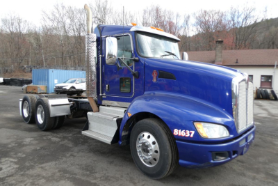 Kenworth T660 conventional daycab truck in blue, side view showing exhaust stacks and chrome accents.