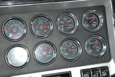 Kenworth T660 dashboard gauges showing fuel, DEF, water temperature, oil pressure, volts, and other indicators in a truck cab dash cluster.