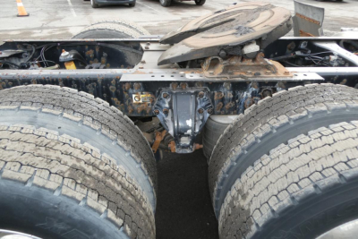 Kenworth T660 tractor rear chassis showing dual rear axles and fifth-wheel plate with surrounding drivetrain components.