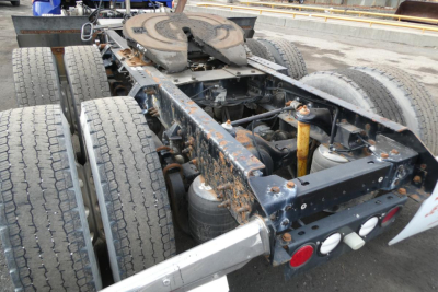 Kenworth T660 chassis and rear section showing dual rear axles, frame rails, and fifth wheel with some wear and exposed suspension components.