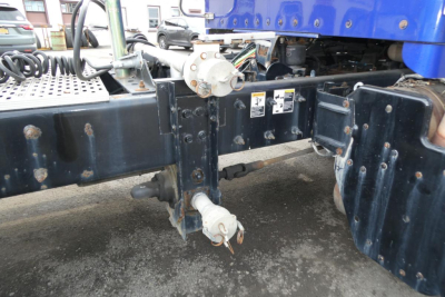 Kenworth T660 chassis undercarriage showing electrical connectors and frame rails with white sensor/valve components.