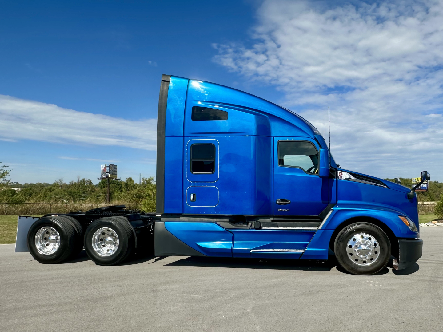 Kenworth T680 2023 side view showing blue sleeper cab and dual rear axles, VIN plate not visible.