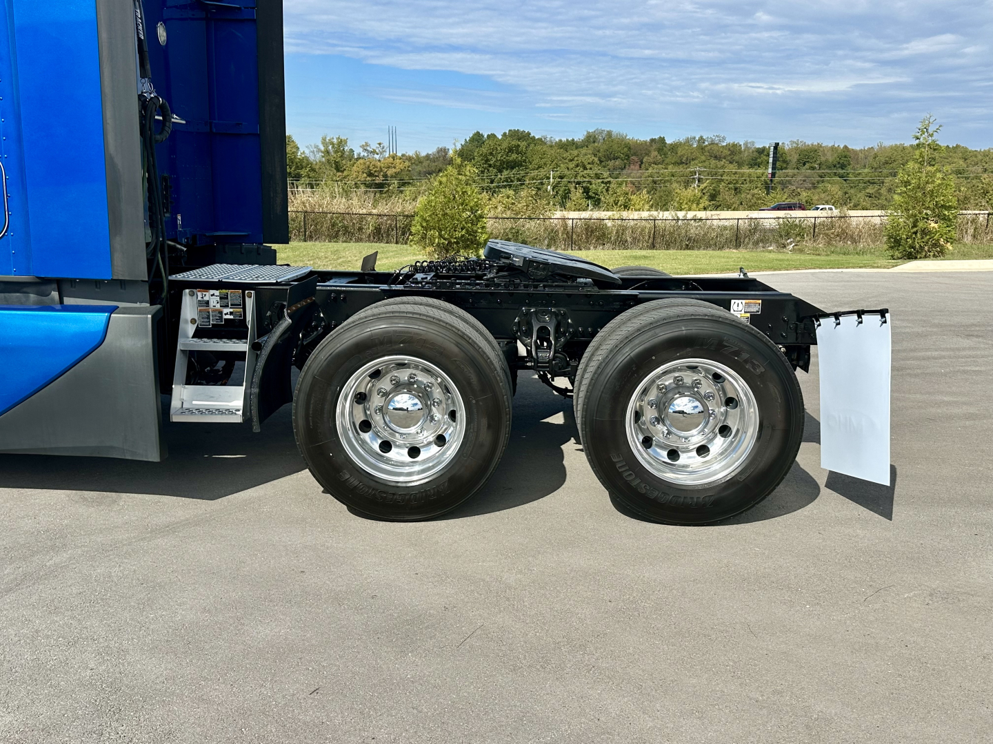 Kenworth T680 truck side view showing dual rear axles with chrome wheels and mud flaps.