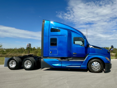 Kenworth T680 2023 side view showing blue sleeper cab and dual rear axles, VIN plate not visible.