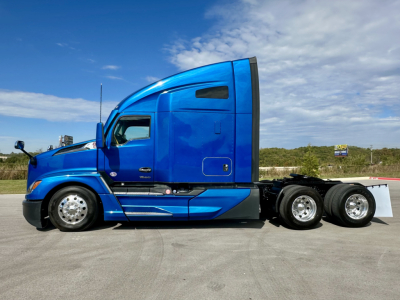 Kenworth T680 conventional sleeper truck in blue, side view showing cab with aerodynamic contours and dual rear axles.