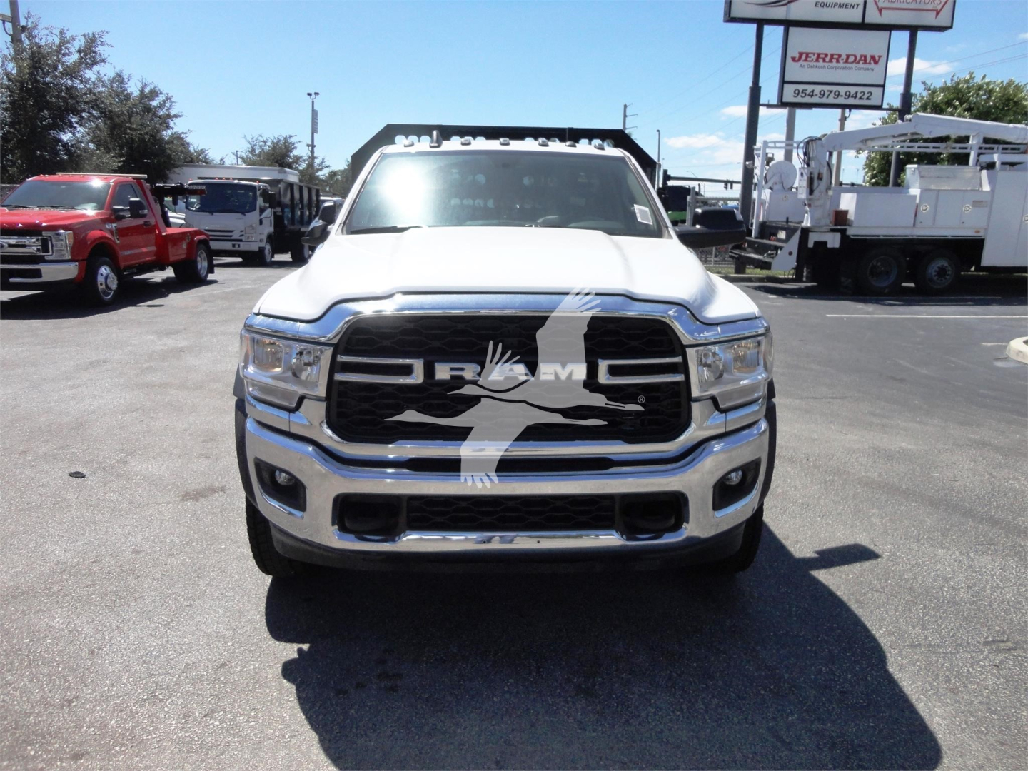Ram 5500 front view showing chrome grille with RAM logo and large bumper, in a dealership lot.
