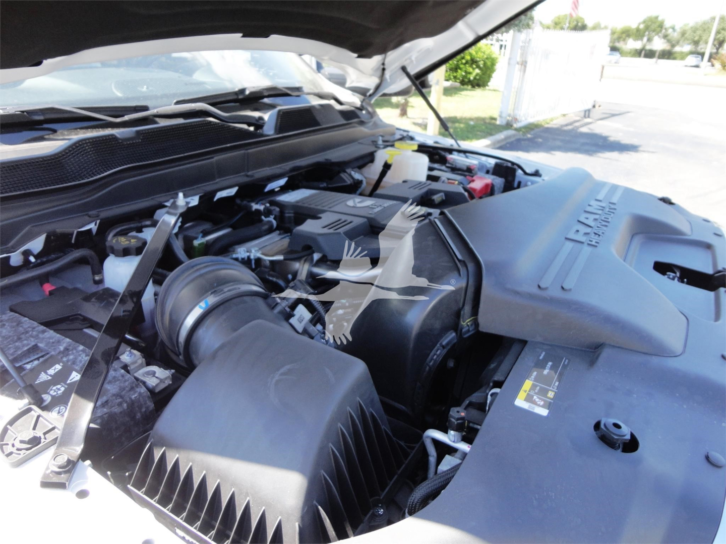 Ram 5500 HD engine bay with open hood showing air intake and engine components; visible coolant reservoir cap and various labels.