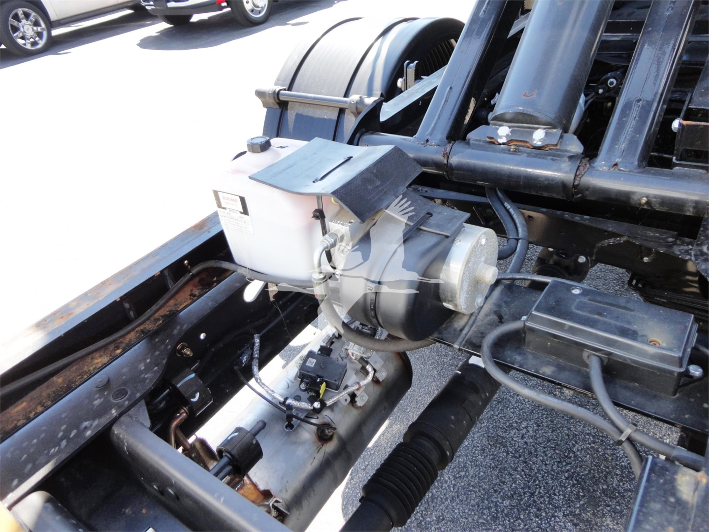 Ram 5500 HD hooklift truck chassis showing hydraulic pump and reservoir.