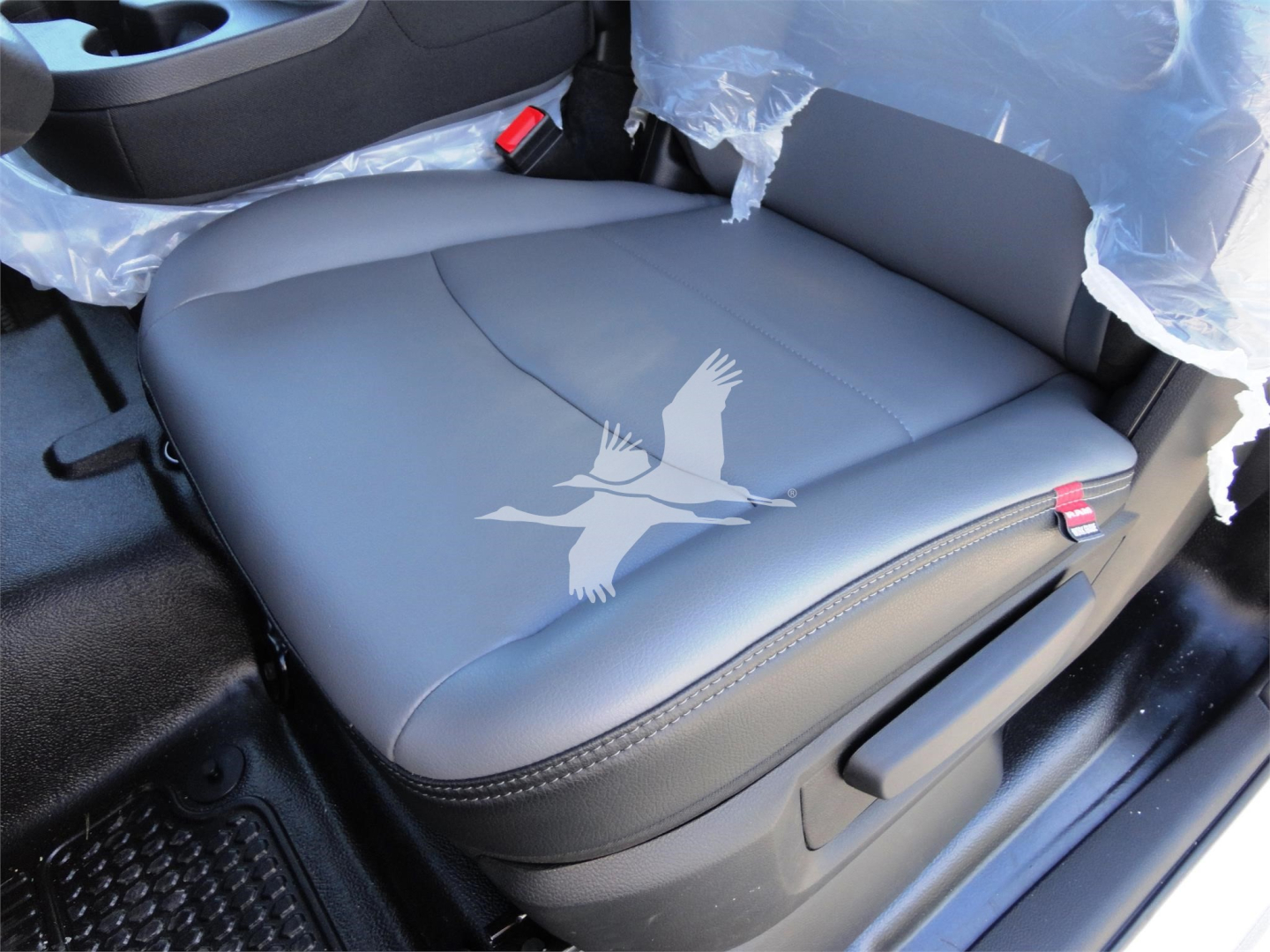 Ram 5500 cab interior showing gray seat with plastic cover and red seatbelt buckle.