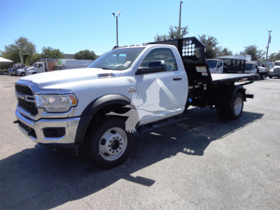 Ram 5500 HD hooklift truck in white with black flatbed and crane lights showing side graphic and front grille.