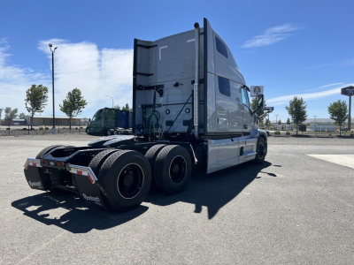 Mack PR64T76H conventional sleeper truck in a parking lot, rear and side view showing fifth wheel, drivetrain, and rear tires.