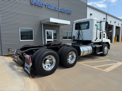 Tractor unit view of a 2020 Mack Anthem daycab showing dual rear axles and chrome wheels in a used truck lot.