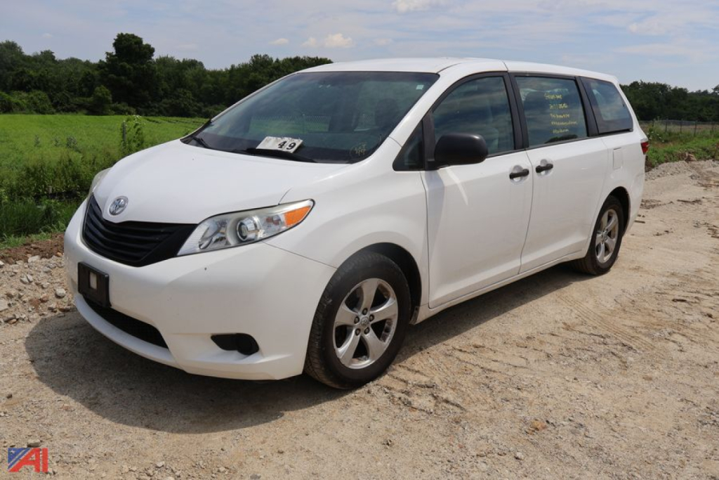 White 2017 Toyota Sienna minivan seen from front-left angle in dirt lot.