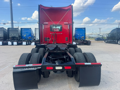 Truck rear chassis and fifth wheel area of a 2021 Peterbilt 579 daycab showing dual rear axles, mud flaps, and rear lighting.