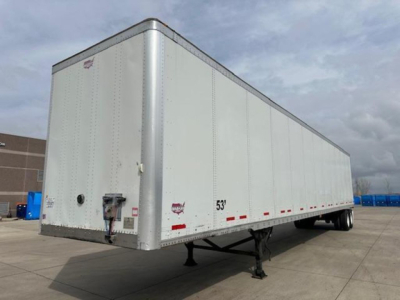 Trailer side view showing a white 2016 Wabash van trailer with a raised front nose, side door, dual tires at rear, and support legs down. Visible markings include red reflective tape along bottom edge and small stickers near front corner.