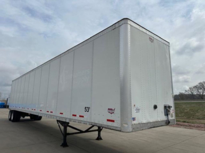 Trailer side and front of a white 53' Wabash van trailer with stock decals and small logos visible on the nose and siderail.
