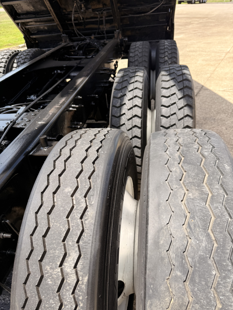 Mack GU713 rear dual axle tires and chassis frame in a truck bed area; focus on tandem rear wheels with tread patterns visible.