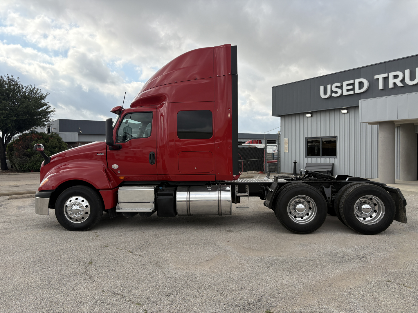 2022 International LT truck in red side view showing sleeper cab and dual rear axles.