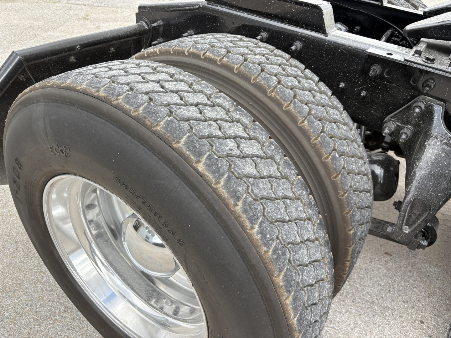 Truck front wheel and dual rear tires on International LT chassis showing tread and suspension components.