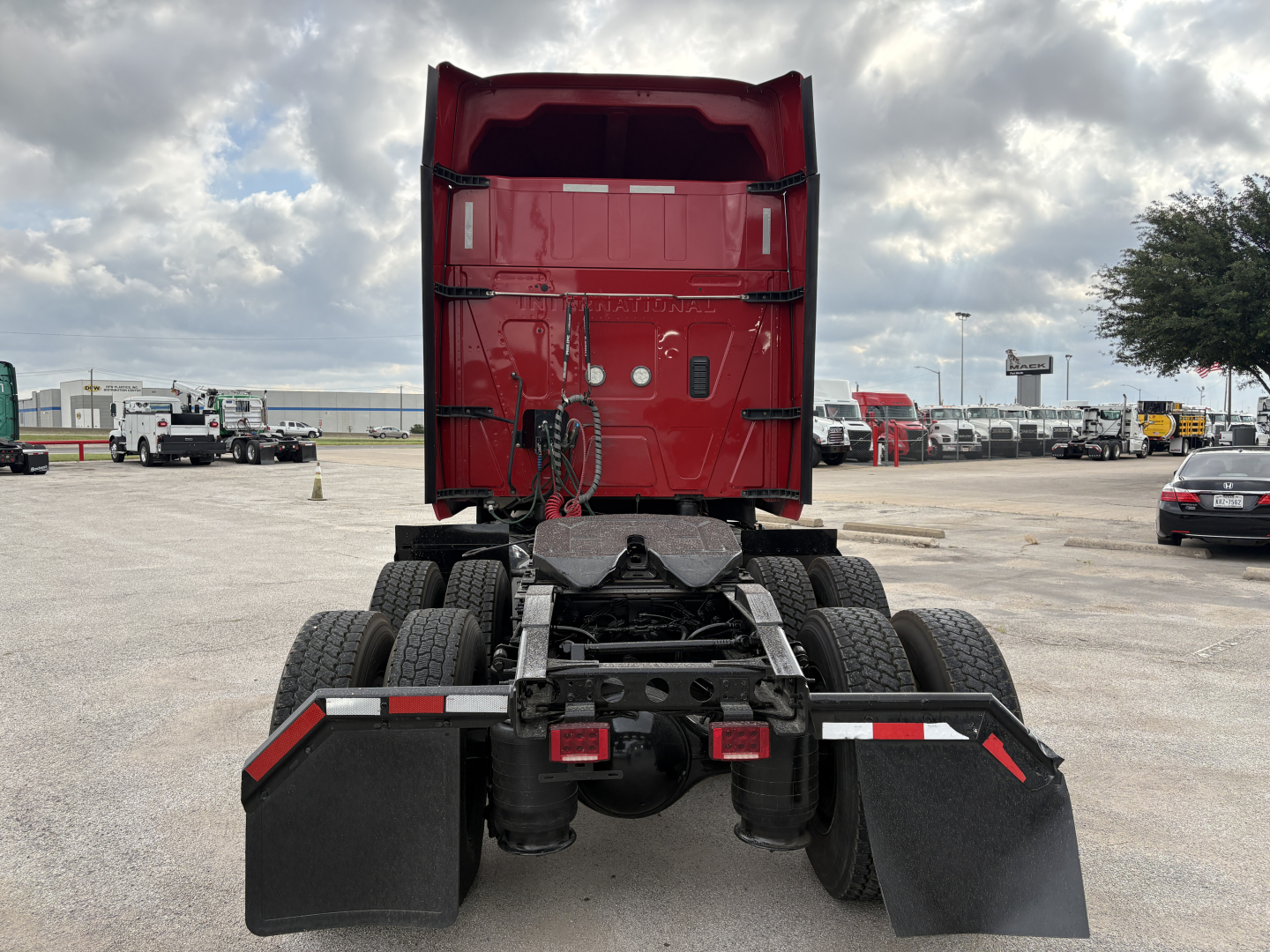 Truck chassis and rear view of a red 2022 International LT sleeper tractor showing the fifth-wheel mounting and dual rear axles with mud flaps.