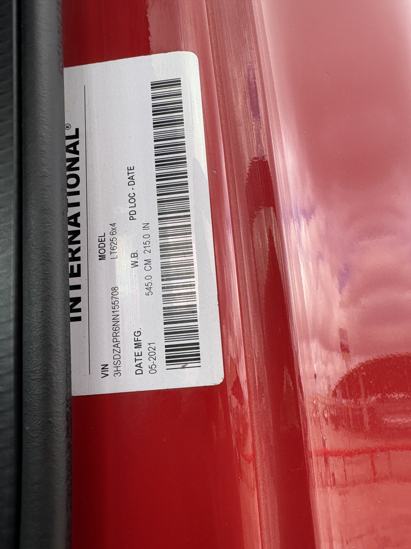 International truck label on door frame with barcode and VIN details visible; white sticker shows INTERNATIONAL text and barcodes.