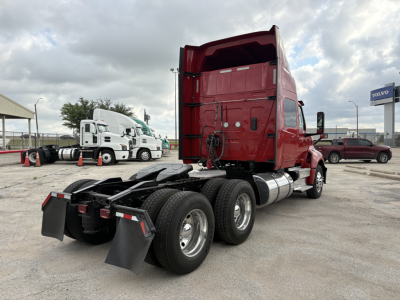 Truck cab and dual rear axles of a red 2022 International LT sleeper tractor showing rear wheels and fifth wheel area.