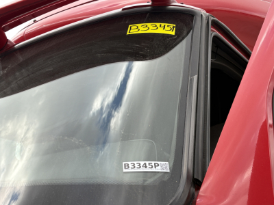 Vehicle windshield with B3345P sticker and B3345P label visible on passenger window of red truck, 2022 International LT listing