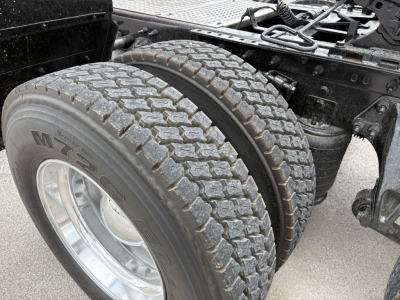 Dual rear tires on a truck tractor showing MT-OL brand skid tread and dual wheel setup with frame and suspension components.