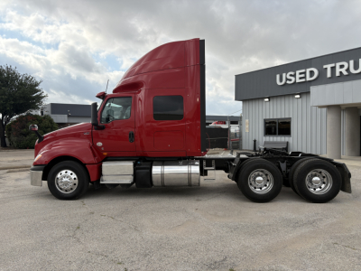 2022 International LT truck in red side view showing sleeper cab and dual rear axles.