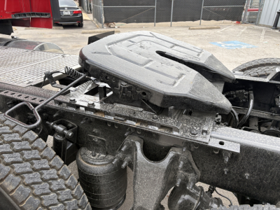 Tractor-trailer fifth wheel and coupling area with air reservoir and exposed frame; visible components include the hitch mounting and suspension near the rear wheels.