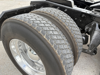 Truck front wheel and dual rear tires on International LT chassis showing tread and suspension components.