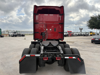 Truck chassis and rear view of a red 2022 International LT sleeper tractor showing the fifth-wheel mounting and dual rear axles with mud flaps.