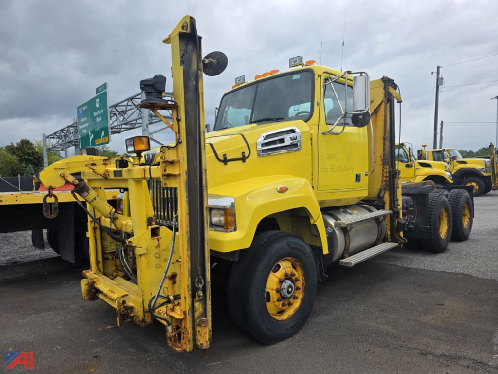 Yellow Western Star 4700 SF cab and chassis truck with mounted heavy-duty boom and winch, front view showcasing front axle, grille, and windshield.