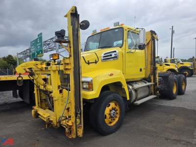 Yellow Western Star 4700 SF cab and chassis truck with mounted heavy-duty boom and winch, front view showcasing front axle, grille, and windshield.