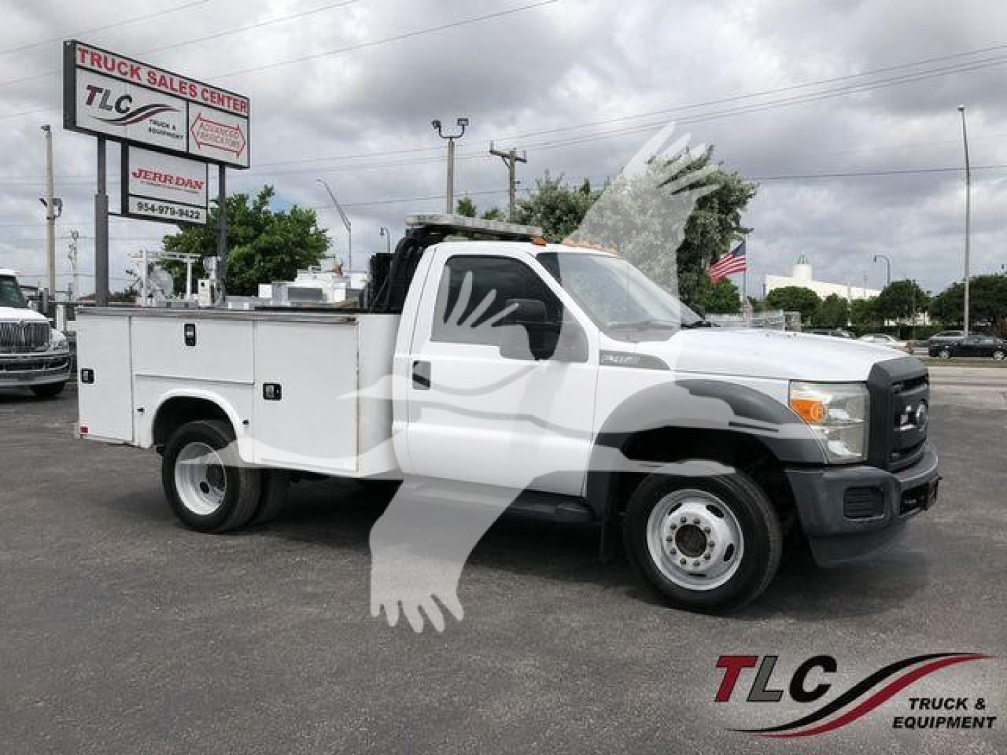 Ford F-450 service/utility truck with utility body and cab, side view showing TLC dealership signage in background.
