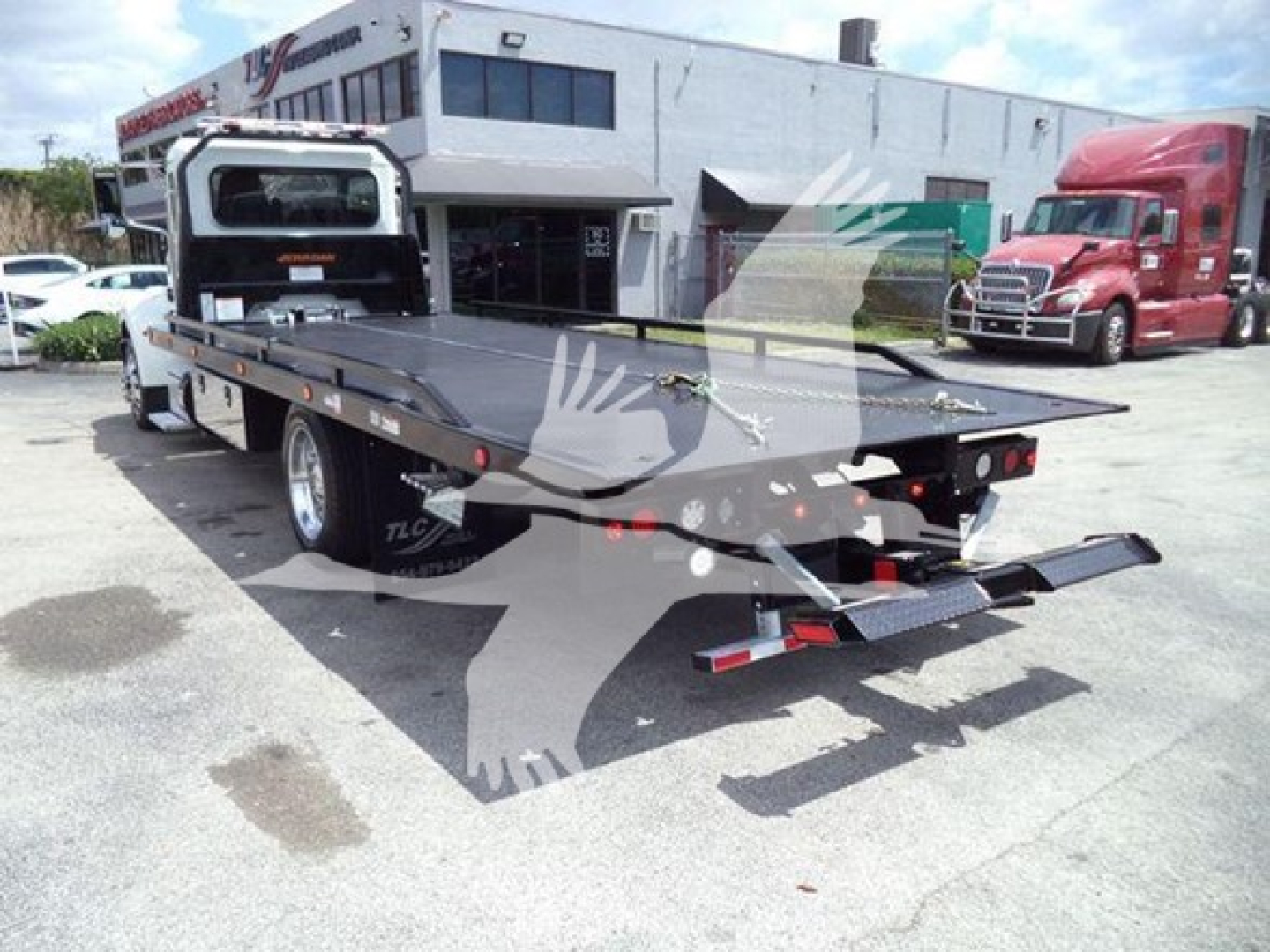 Peterbilt 337 rollback truck rear view showing flatbed and tow equipment with license plate area and rear lights.