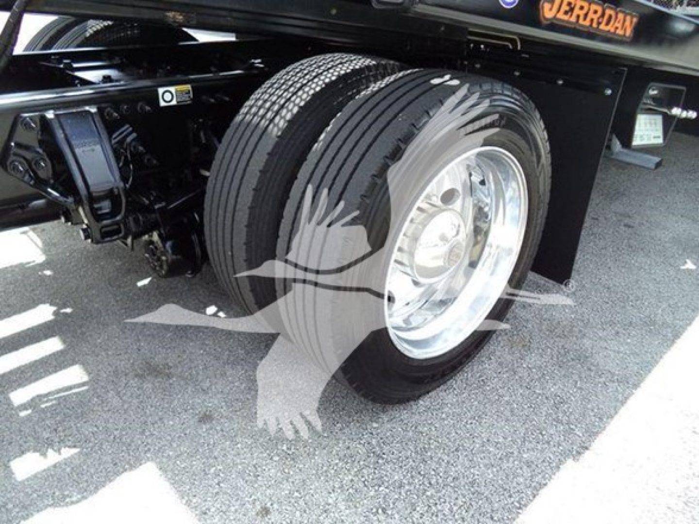 Peterbilt 337 rollback truck rear wheel and suspension showing dual rear tires and black undercarriage.