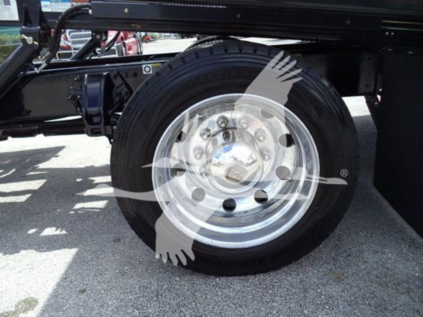 Peterbilt 337 wheel and part of chassis showing aluminum truck wheel with black tire and chrome hubcap.