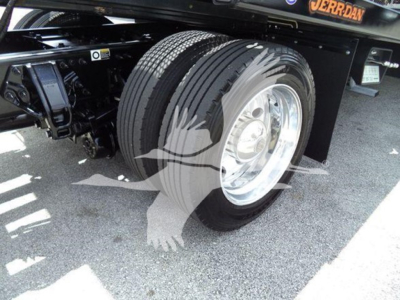 Peterbilt 337 rollback truck rear wheel and suspension showing dual rear tires and black undercarriage.