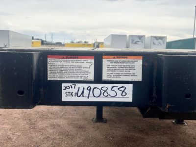 Flatbed trailer rear with warning labels and stock number U90858, VIN 1GRDN9629HH731158 visible.