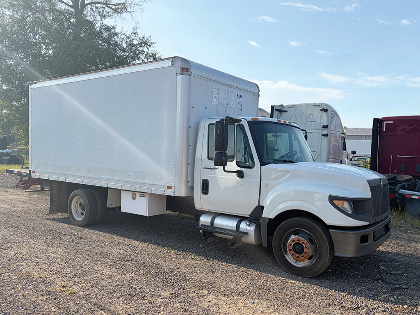 2012 International TerraStar conventional daycab truck with white cab and box body, side view showing front wheel and side mirror