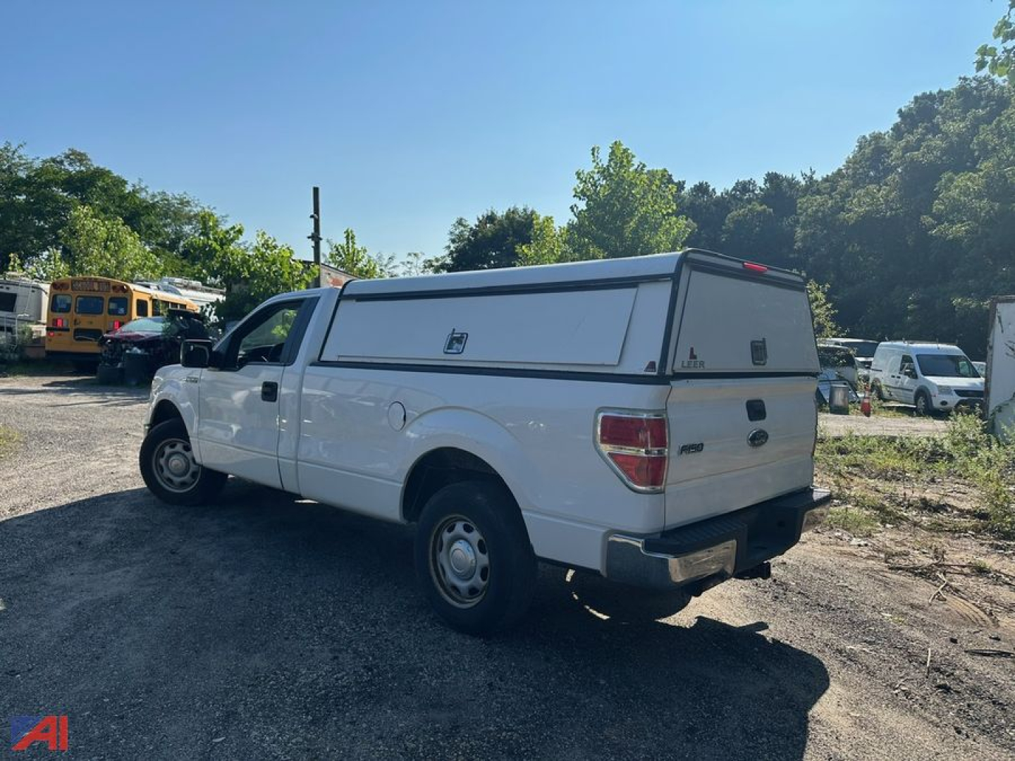 Ford F-150 pickup truck with white cap, rear view showing camper shell and side profile
