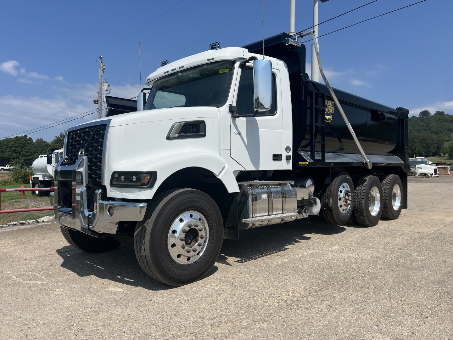 Volvo VHD64F300 dump truck in profile view showing cab, side mirrors, chrome bumper, and black dump bed.