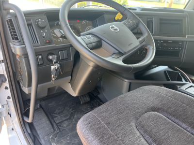 Volvo VHD64F300 truck cabin interior showing steering wheel, dashboard, ignition with key, pedals, and driver seat.