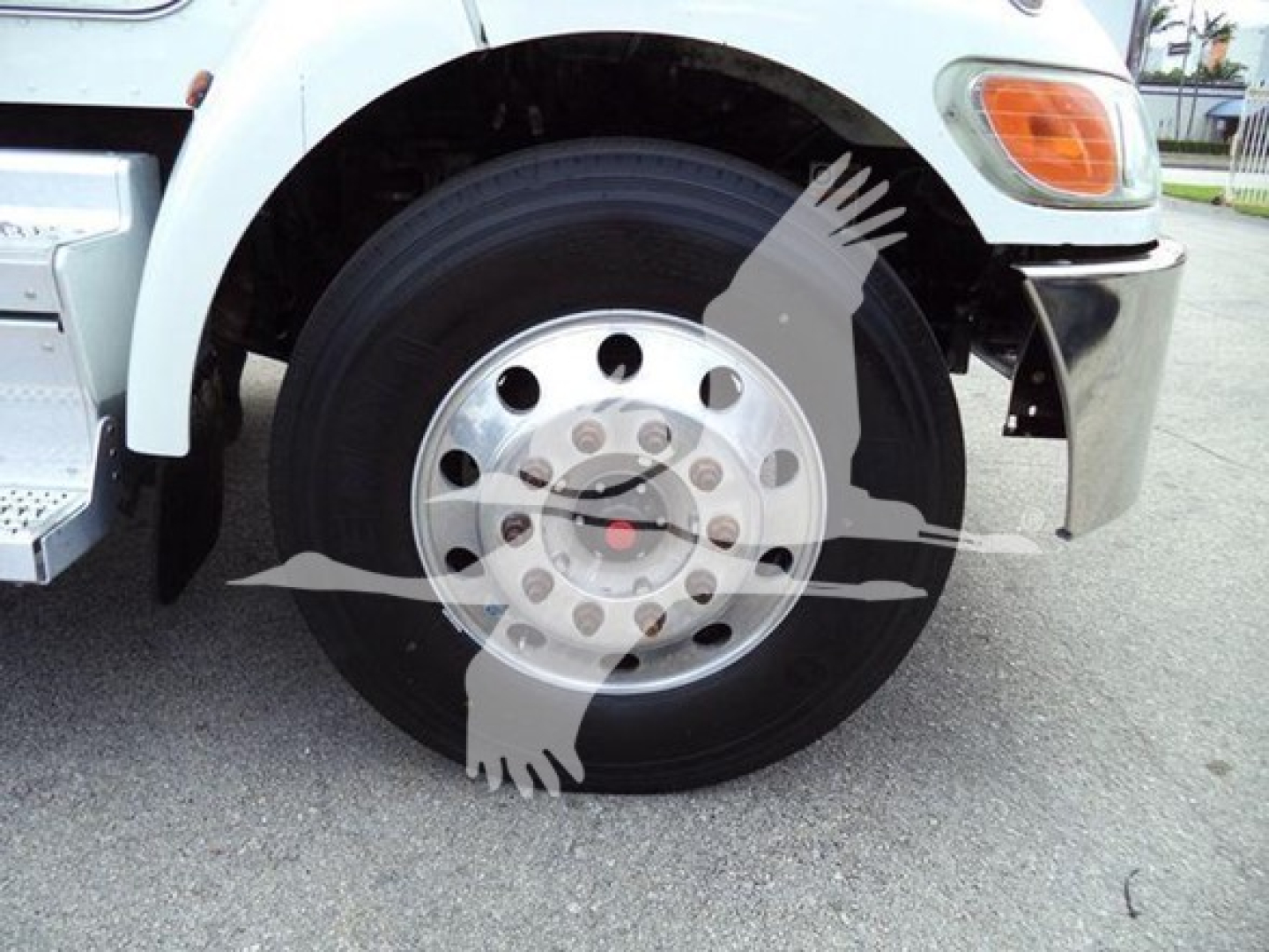 Peterbilt 337 front wheel and fender showing large steel wheel with hub, tire, and part of light assembly.