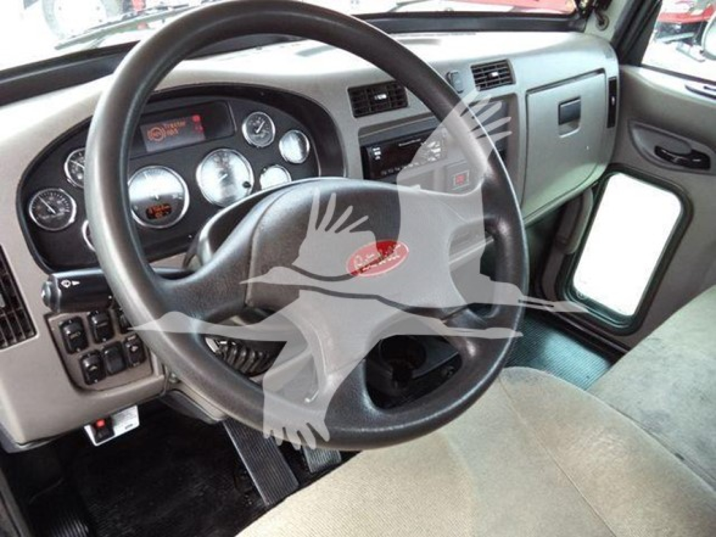 Peterbilt 337 interior showing steering wheel, dashboard gauges, and driver’s door area.