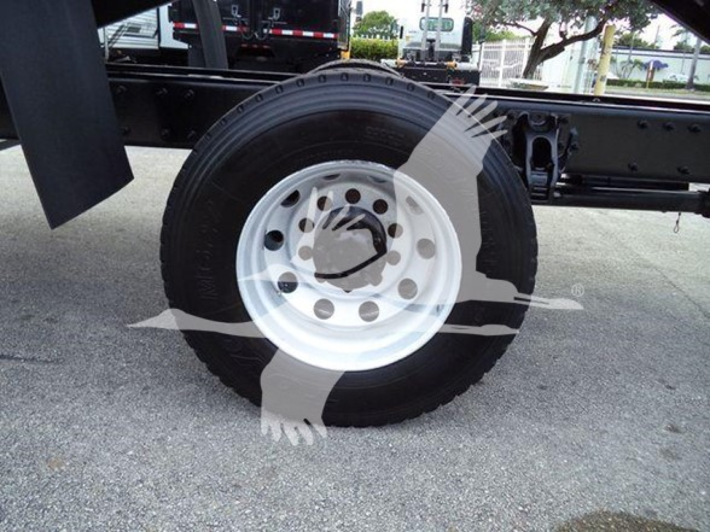Peterbilt 337 wheel and axle assembly visible, white steel rim with lug holes, tire mounted on chassis.