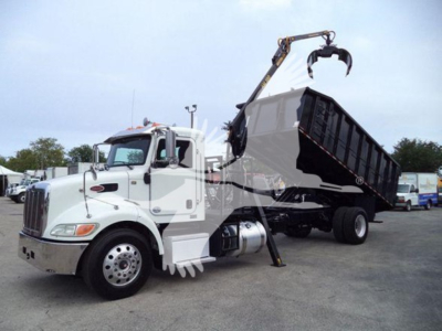 Peterbilt 337 grapple truck in service showing side view with hydraulic lift and dump bed.