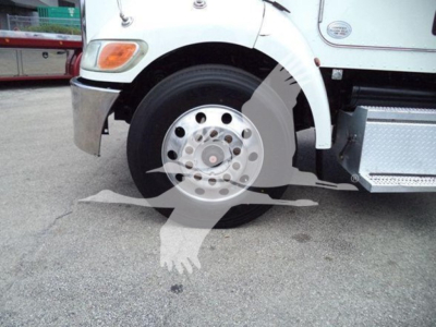 Peterbilt 337 front wheel and fender area showing front wheel, hubcap, chrome bumper, and step plate.