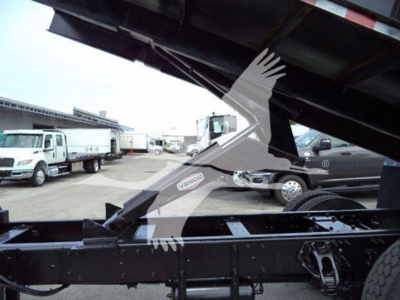 Peterbilt 337 grapple truck chassis frame and hydraulic arm partially raised, visible VIN plate area, truck yard in background.